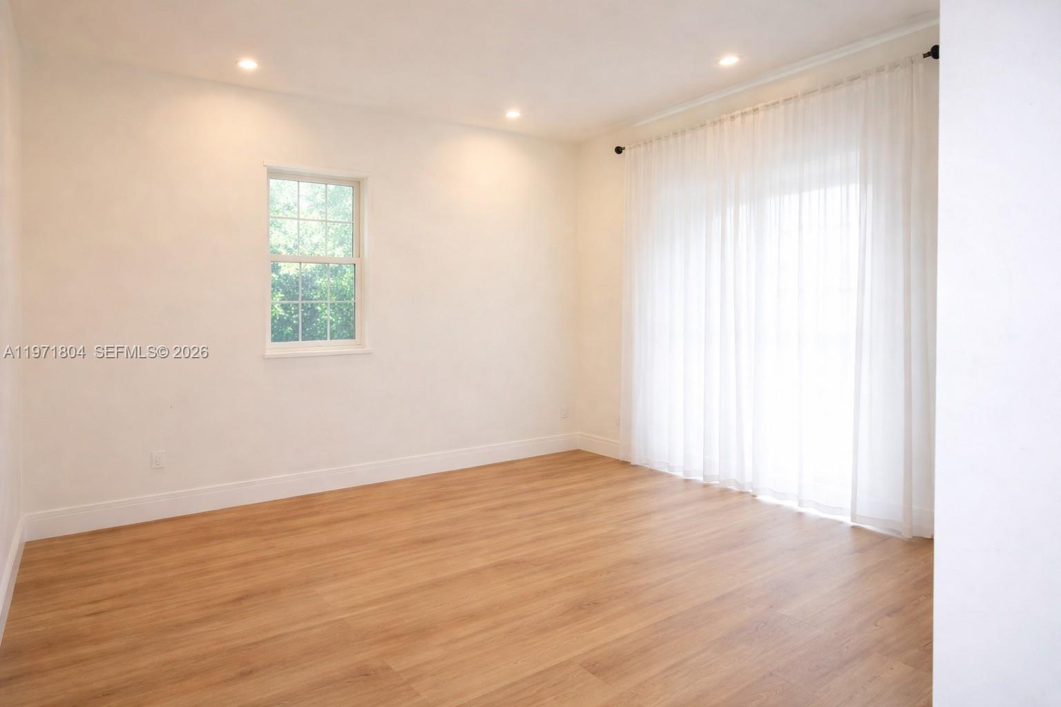 640 Northeast 71st Street Miami, FL 33138 - Photo 6 of 14 an empty room with wooden floor and windows
