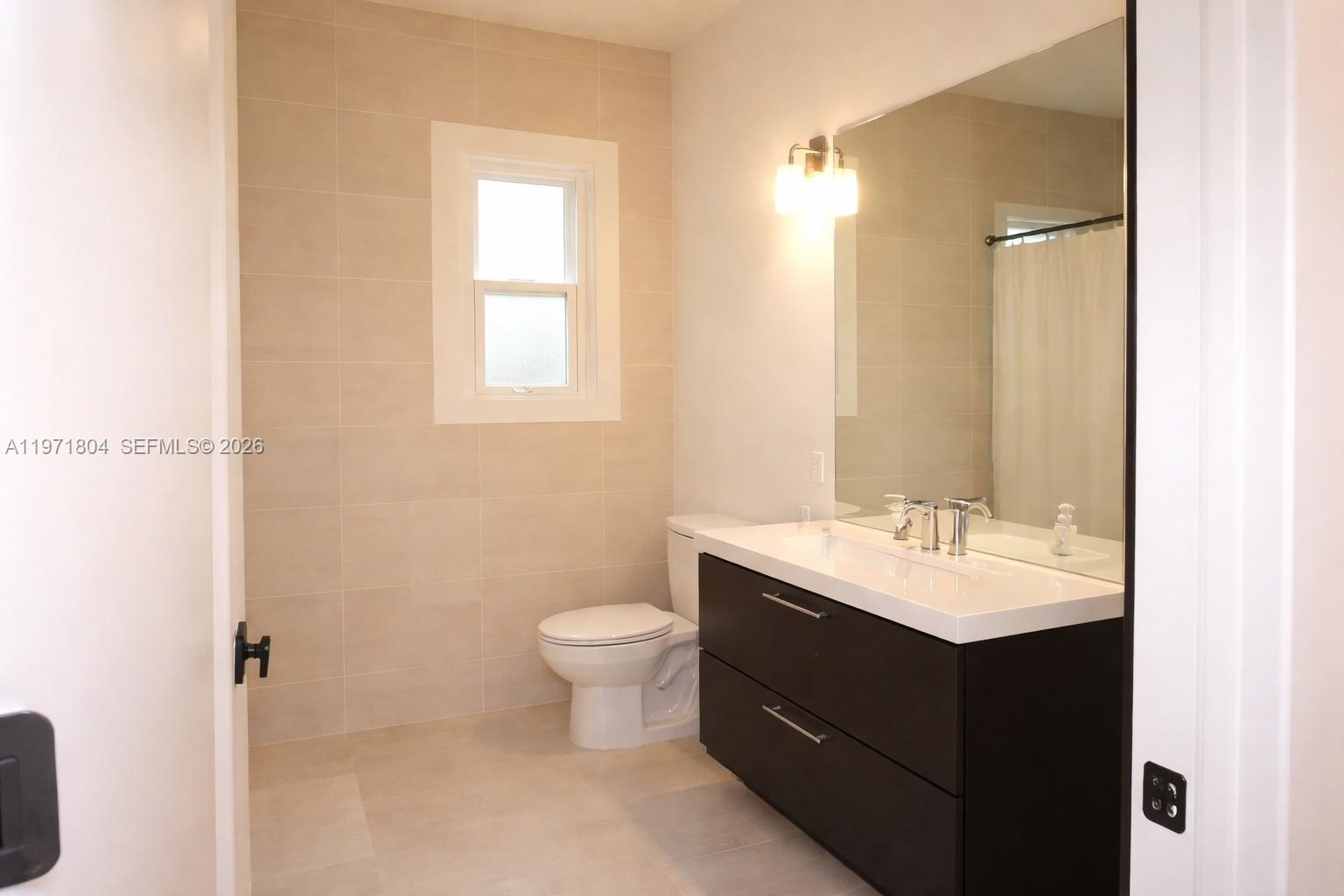 640 Northeast 71st Street Miami, FL 33138 - Photo 8 of 14 a bathroom with a toilet a sink and mirror