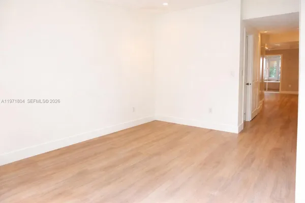 a view of empty room with wooden floor