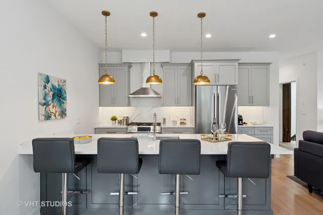 a kitchen with stainless steel appliances a dining table chairs and a refrigerator