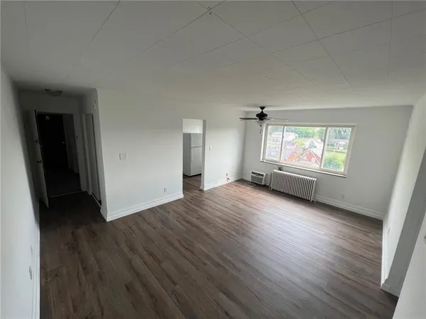 a view of a room that has a bed window and wooden floor