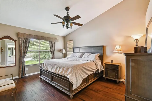 an aerial view of a residential houses with outdoor space and trees