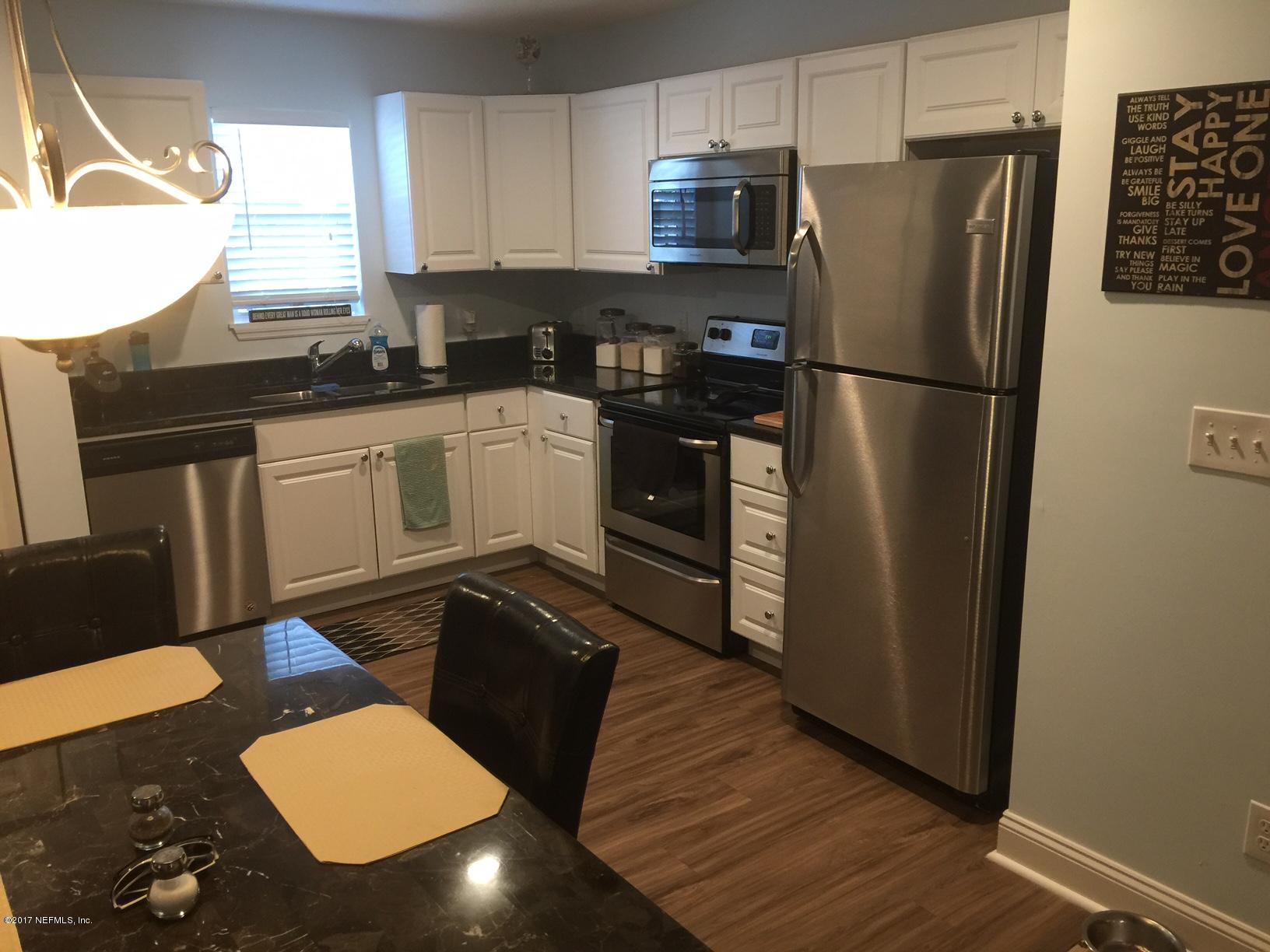 4070 Grant Road Jacksonville, FL 32207 - Photo 8 of 12 a kitchen with granite countertop stainless steel appliances a refrigerator a sink a stove a microwave a counter space and cabinets