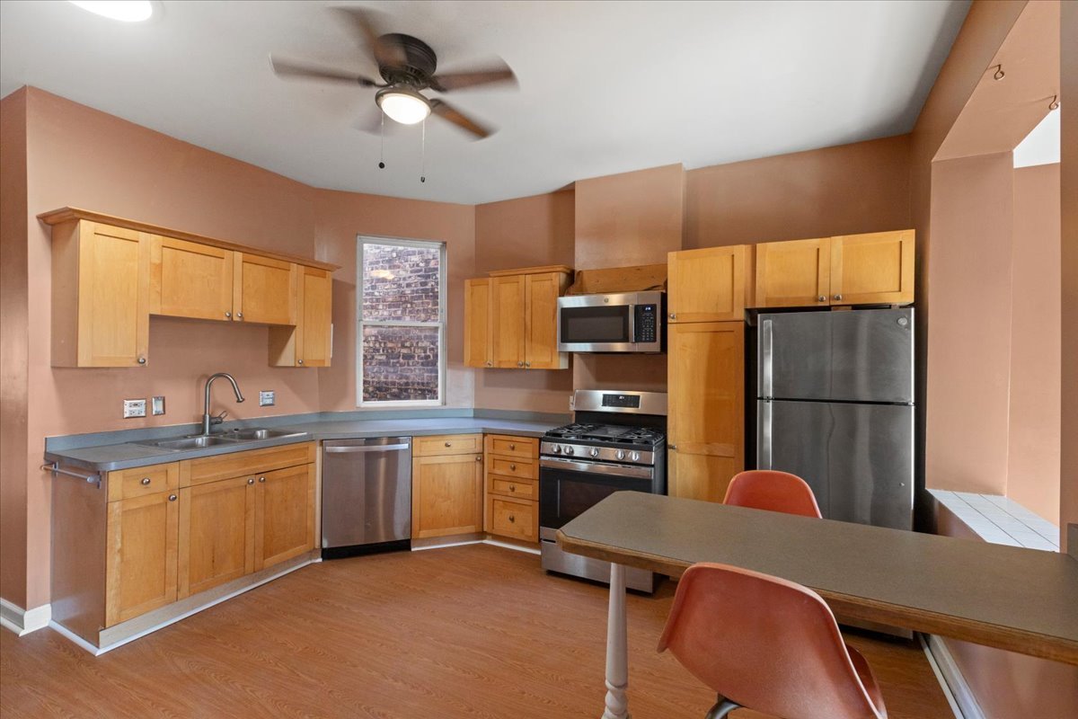 3145 West Augusta Boulevard, Unit 2 Chicago, IL 60622 - Photo 20 of 29 a kitchen with stainless steel appliances granite countertop a sink a stove a dining table and chairs