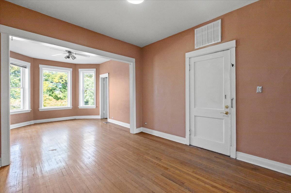 3145 West Augusta Boulevard, Unit 2 Chicago, IL 60622 - Photo 7 of 29 a view of an empty room with wooden floor and a window