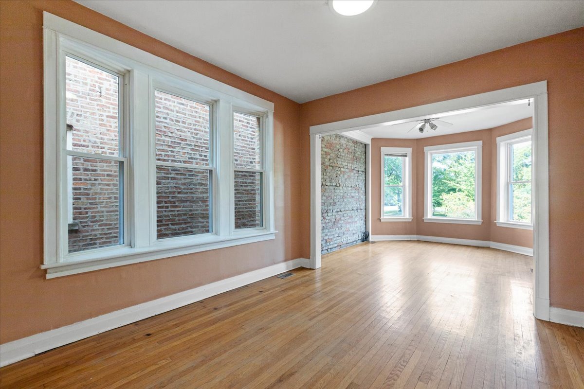 3145 West Augusta Boulevard, Unit 2 Chicago, IL 60622 - Photo 9 of 29 a view of an empty room with wooden floor and a window