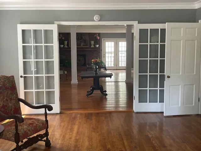 a living room with furniture and a dining table with wooden floor