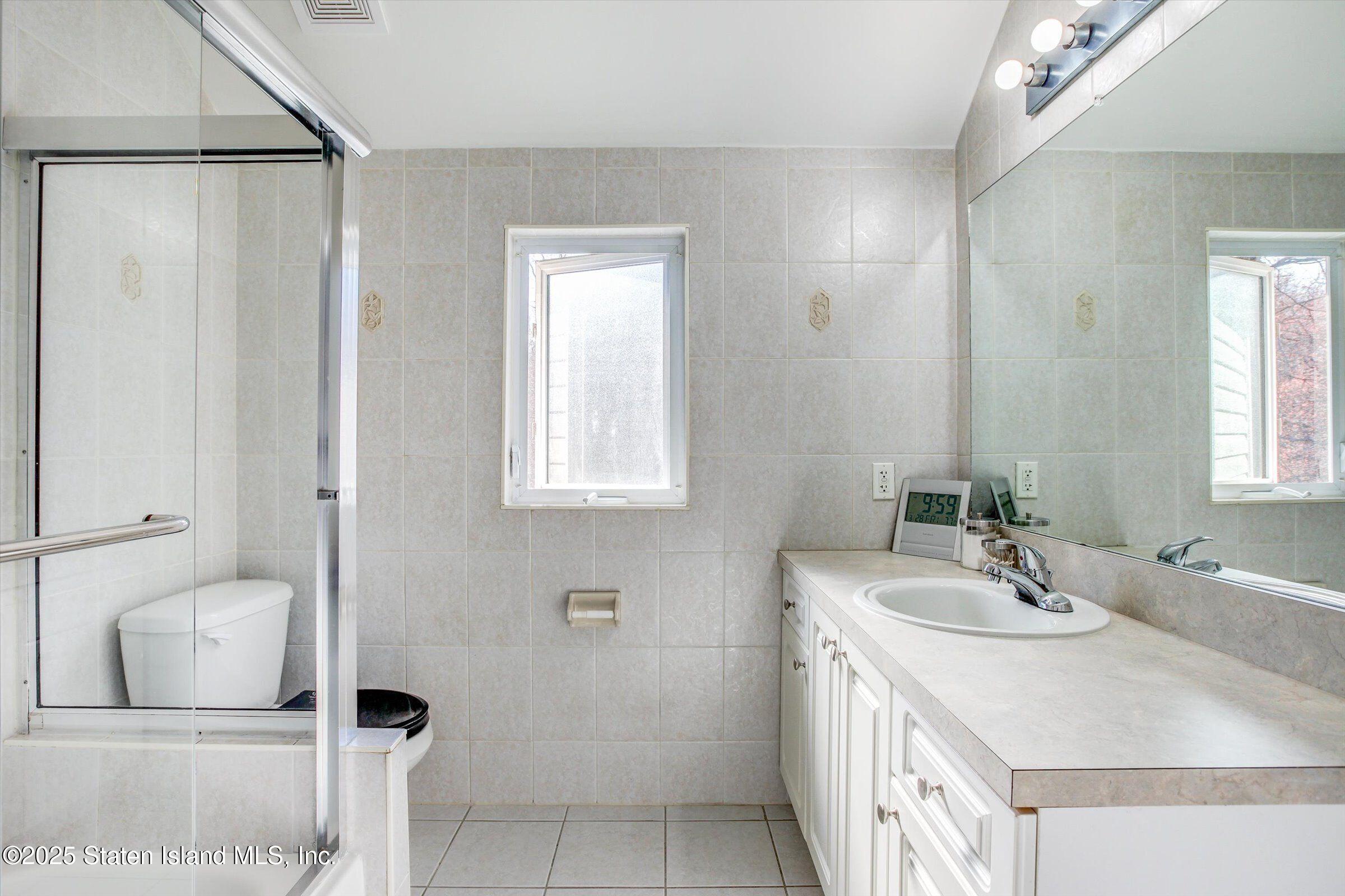 25 Gwenn Loop Staten Island, NY 10314 - Photo 15 of 32 a bathroom with a sink and a mirror