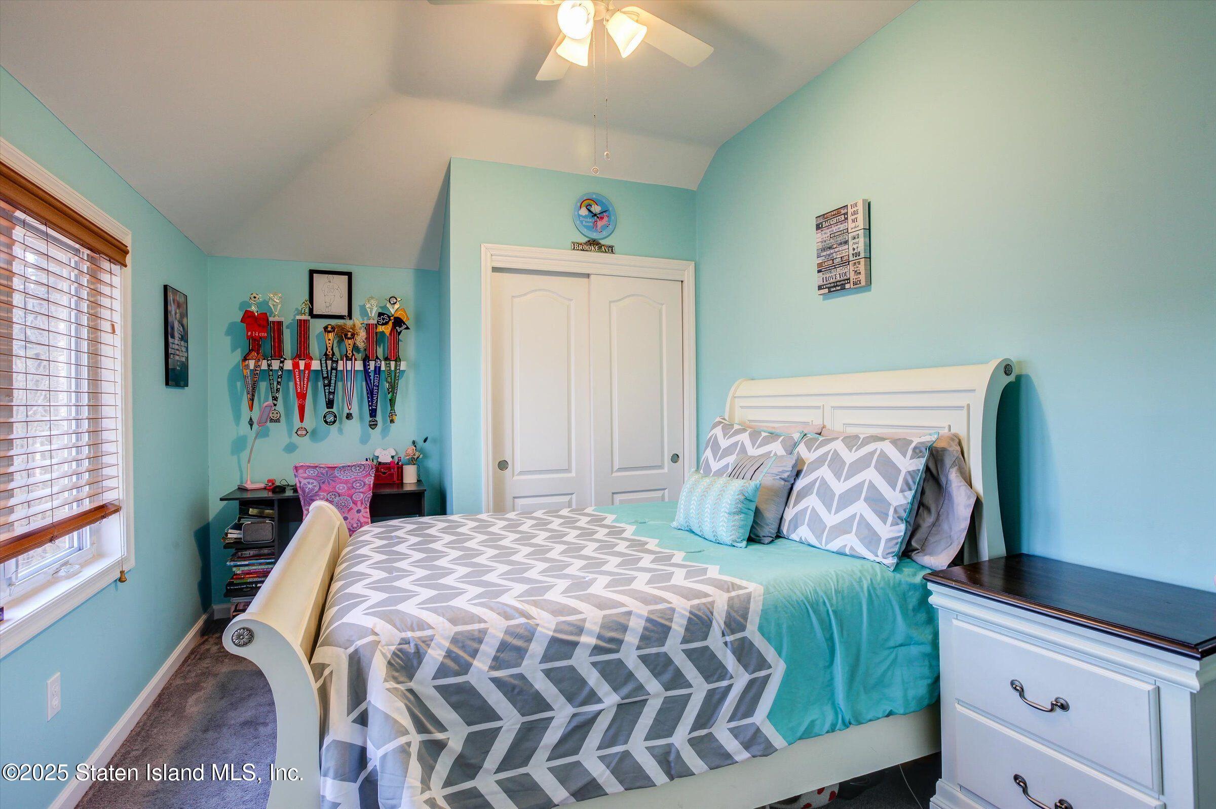 25 Gwenn Loop Staten Island, NY 10314 - Photo 17 of 32 a bedroom with a bed and a chandelier