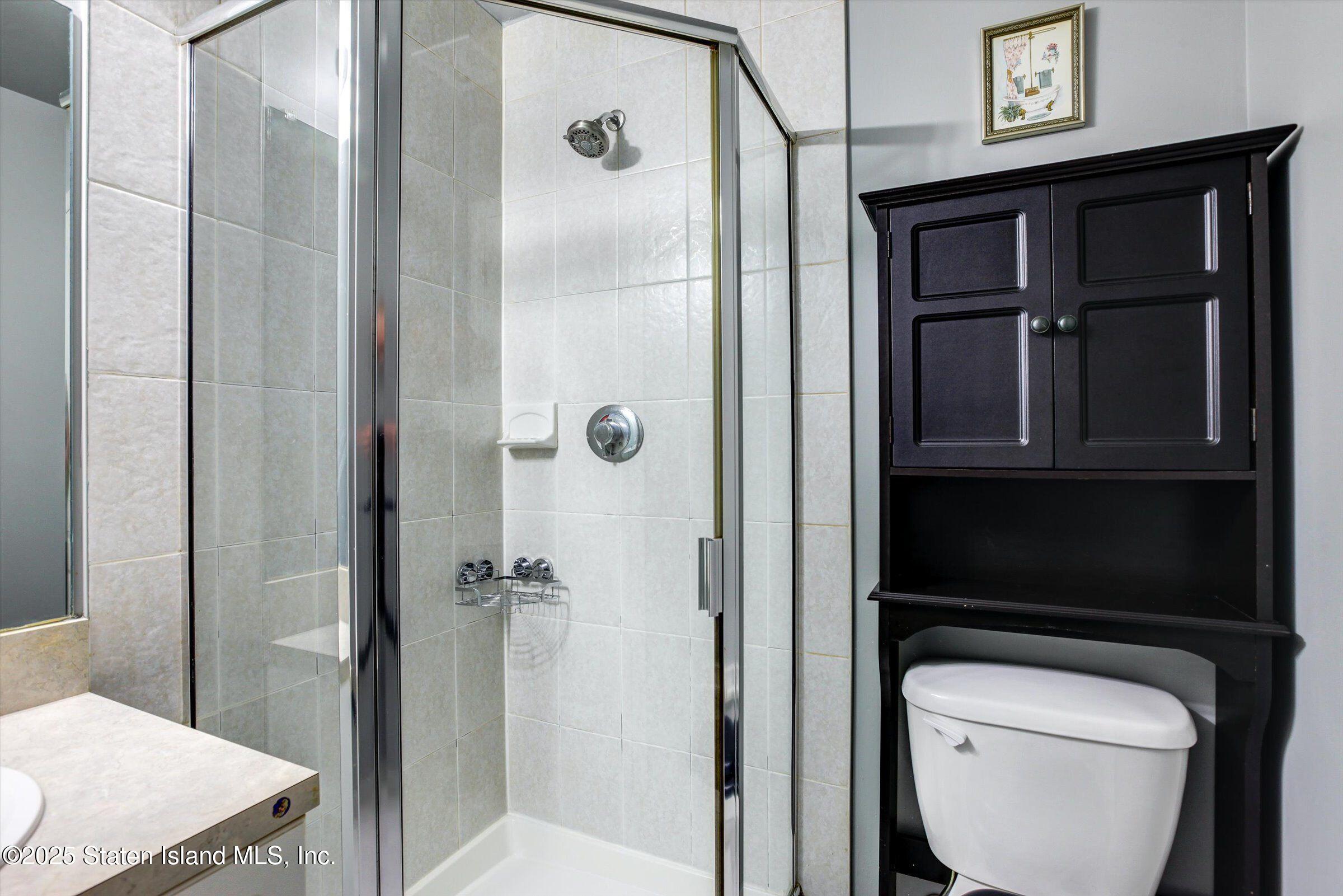 25 Gwenn Loop Staten Island, NY 10314 - Photo 21 of 32 a bathroom with a toilet a sink and shower