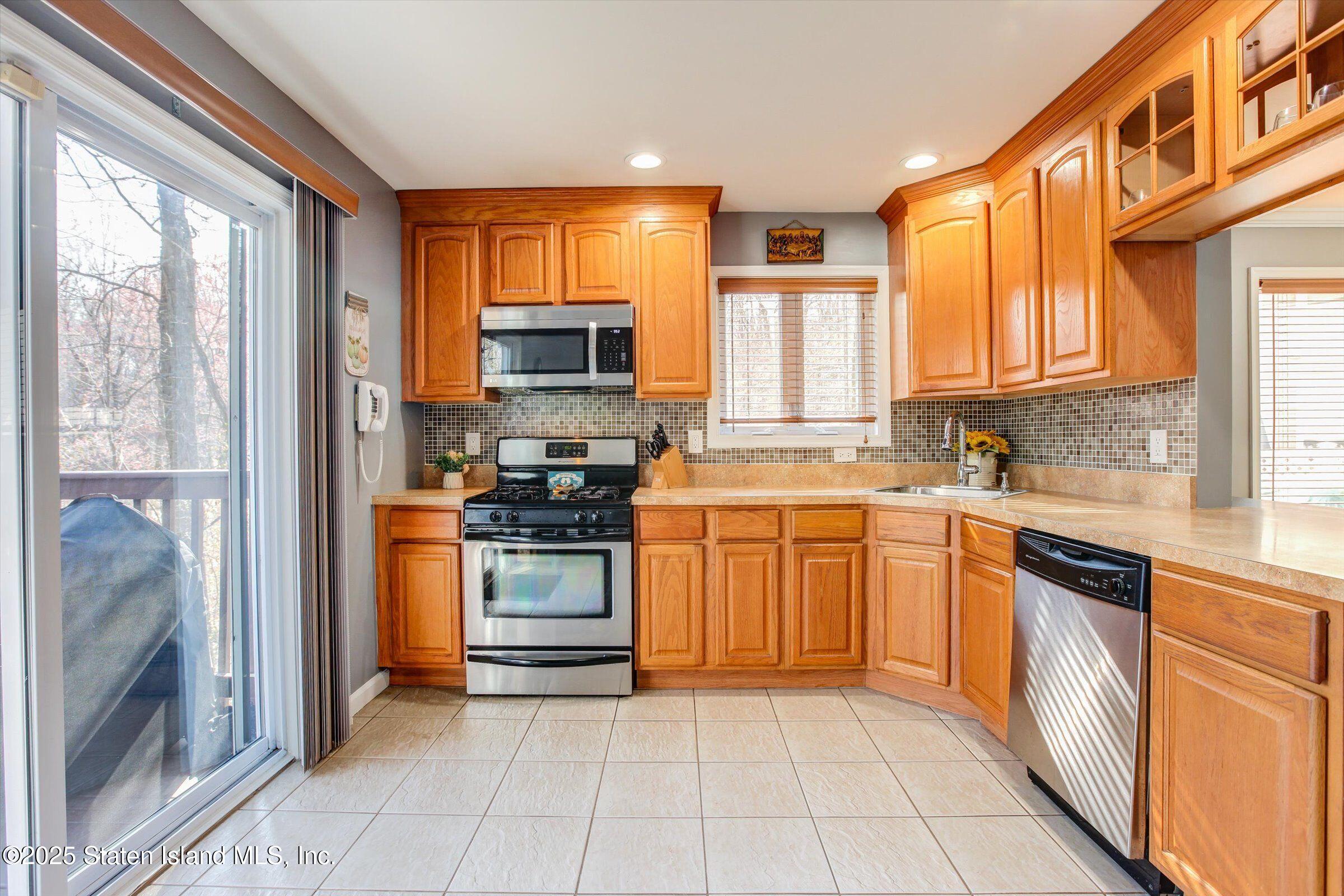 25 Gwenn Loop Staten Island, NY 10314 - Photo 8 of 32 a kitchen with stainless steel appliances granite countertop a refrigerator and a stove top oven