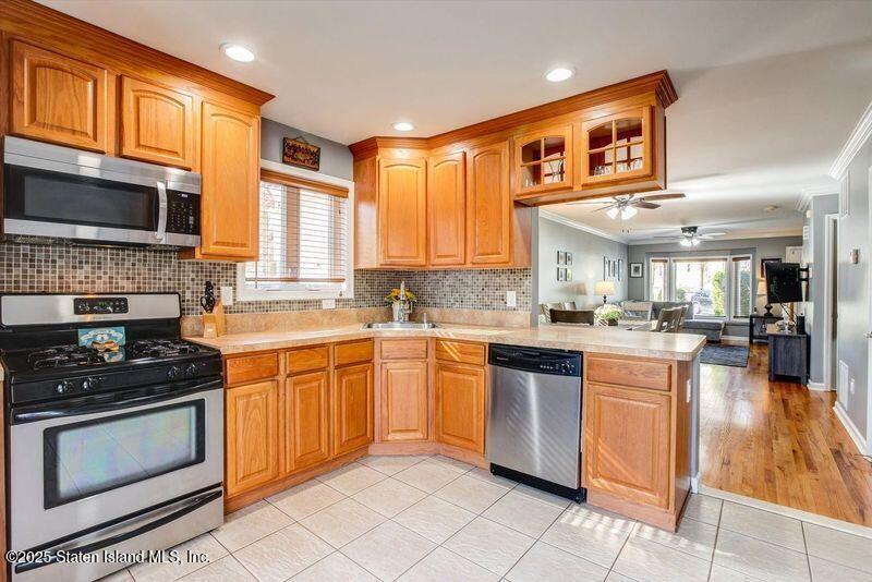 25 Gwenn Loop Staten Island, NY 10314 - Photo 10 of 32 a kitchen with stainless steel appliances granite countertop a stove top oven a sink dishwasher and a microwave oven on the blue kitchen countertops