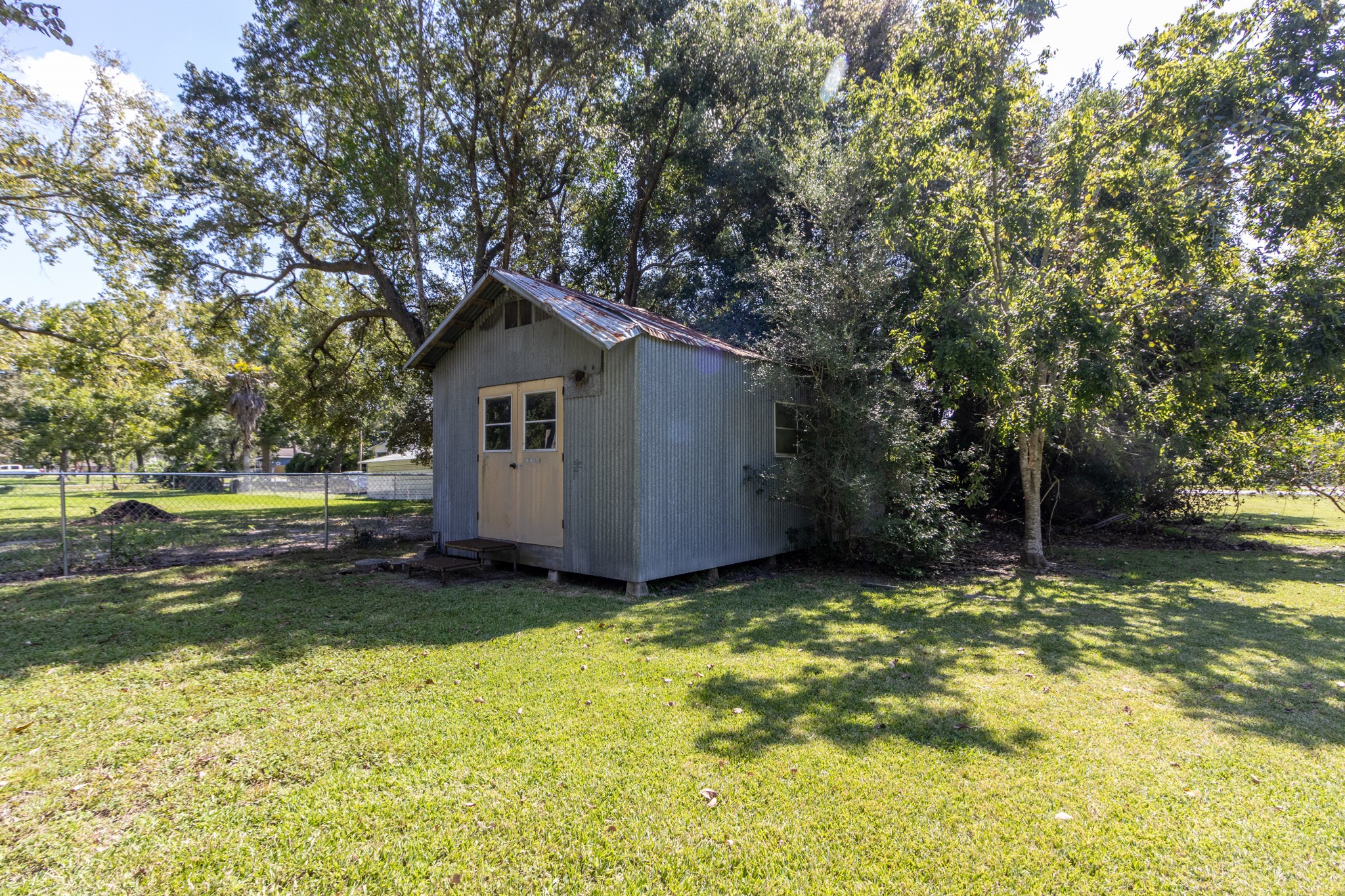 24-th 24th Street Santa Fe, TX 77510 - Photo 5 of 18 a view of a backyard with large trees and a small barn
