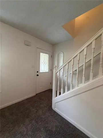 a view of an empty room with wooden floor and windows
