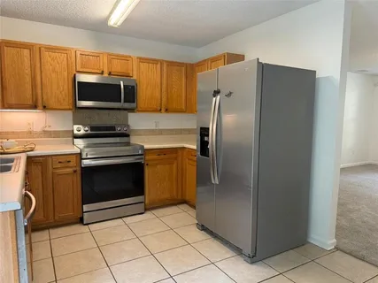 a kitchen with stainless steel appliances granite countertop a refrigerator and a stove top oven