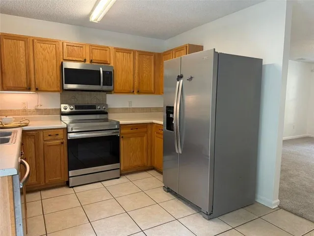 a kitchen with stainless steel appliances granite countertop a refrigerator and a stove top oven