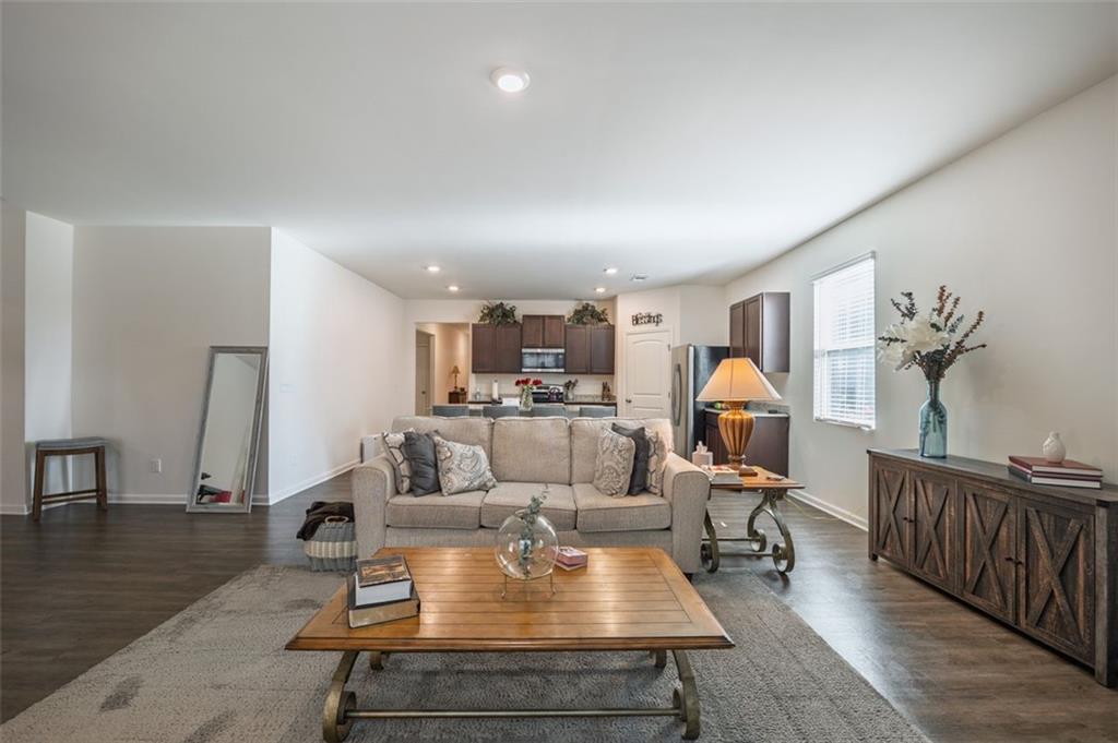 3841 Makeover Court Atlanta, GA 30349 - Photo 13 of 44 a living room with furniture a rug and a chandelier