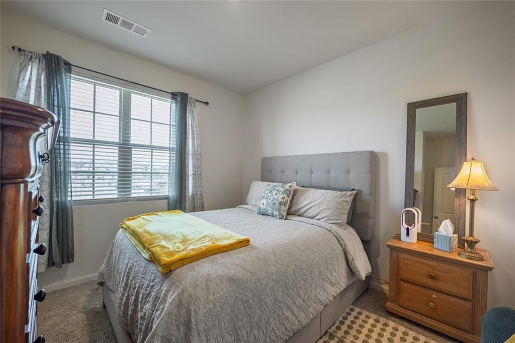 3841 Makeover Court Atlanta, GA 30349 - Photo 18 of 44 a bedroom with a bed and a lamp on dresser