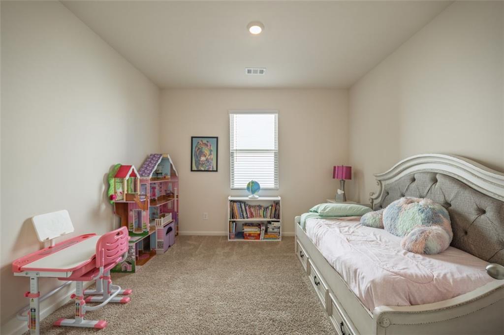 3841 Makeover Court Atlanta, GA 30349 - Photo 25 of 44 a bedroom with a bed and a chair