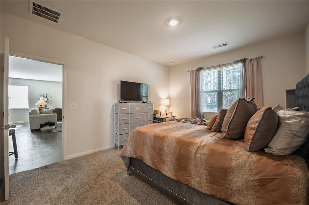 3841 Makeover Court Atlanta, GA 30349 - Photo 30 of 44 a bedroom with a bed and a flat screen tv
