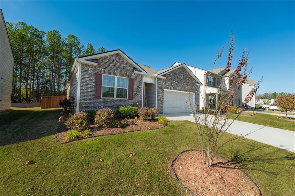 3841 Makeover Court Atlanta, GA 30349 - Photo 39 of 44 a backyard of a house with table and chairs plants and large tree
