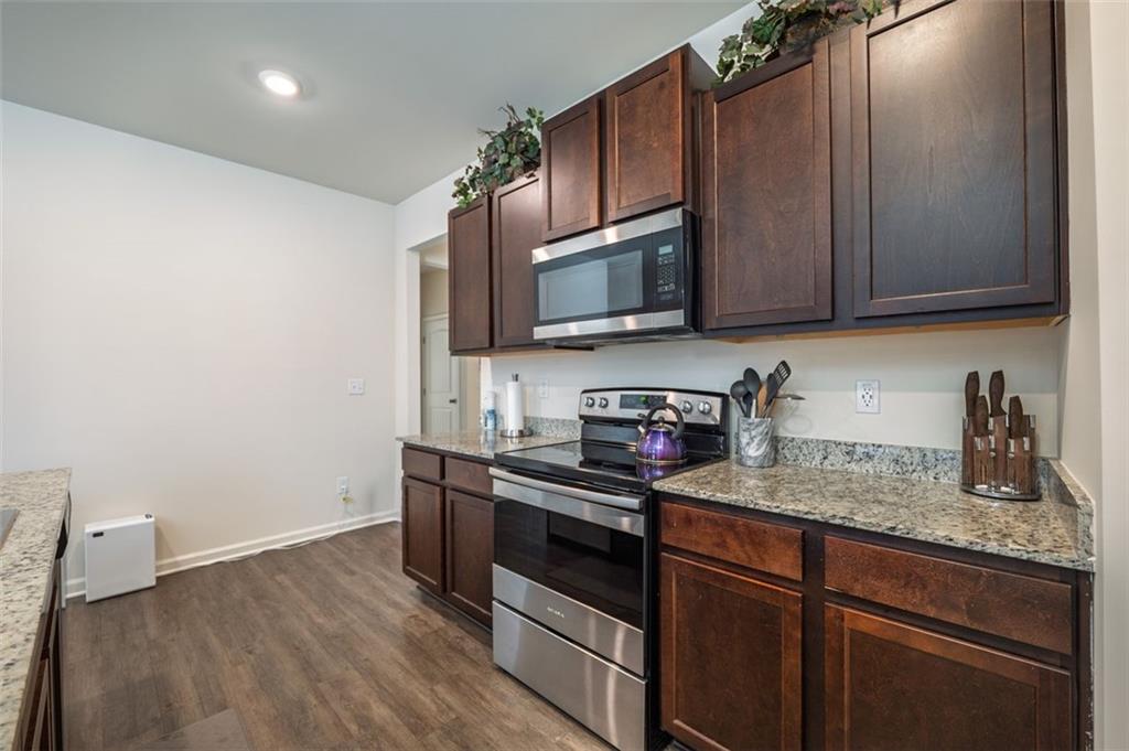 3841 Makeover Court Atlanta, GA 30349 - Photo 10 of 44 a kitchen with sink a microwave a stove and cabinets