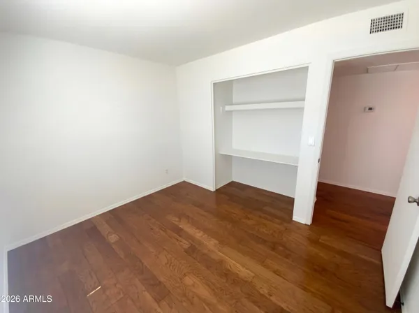 a view of empty room with wooden floor