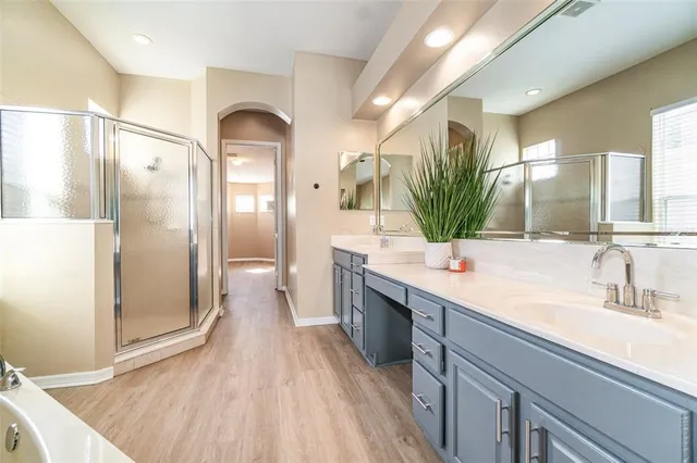a bathroom with a double vanity sink mirror and shower