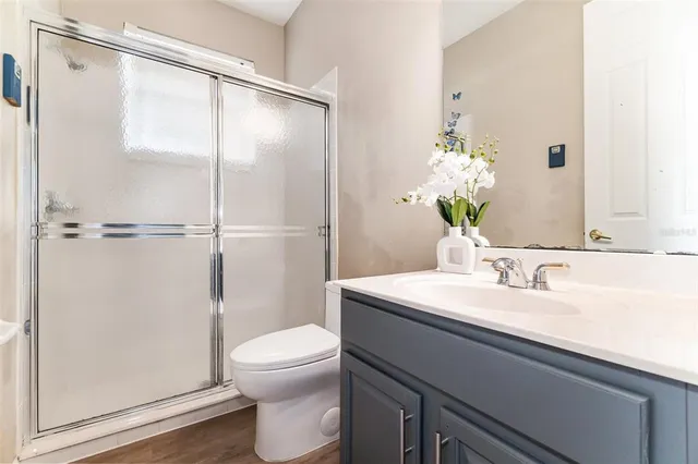 a bathroom with a granite countertop sink toilet and shower