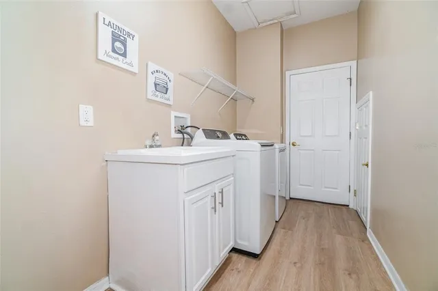 a utility room with sink dryer and washer