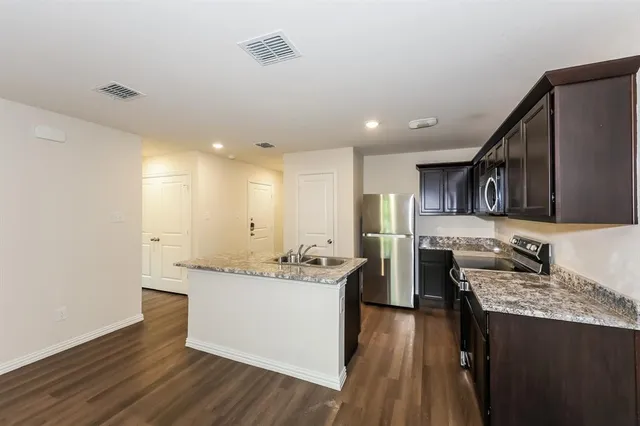 a kitchen with stainless steel appliances granite countertop a sink stove and refrigerator