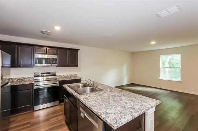 a kitchen with stainless steel appliances granite countertop a sink stove and cabinets