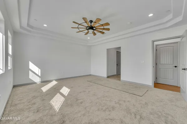 a view of a livingroom with a chandelier fan and windows