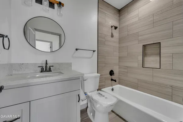 a bathroom with a sink a toilet and a mirror