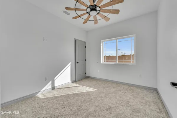 an empty room with windows and fan