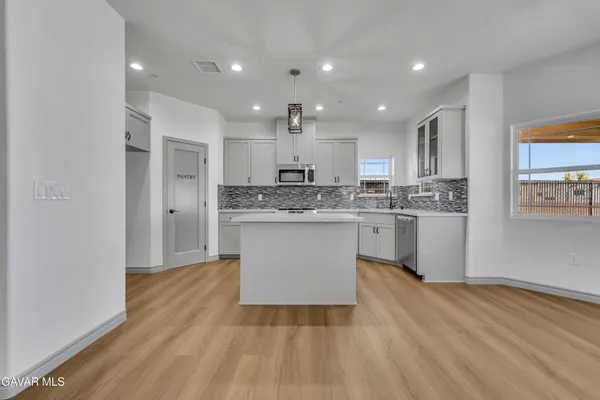 a large kitchen with stainless steel appliances granite countertop a stove a sink dishwasher and a refrigerator