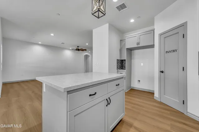 a kitchen with cabinets and wooden floor