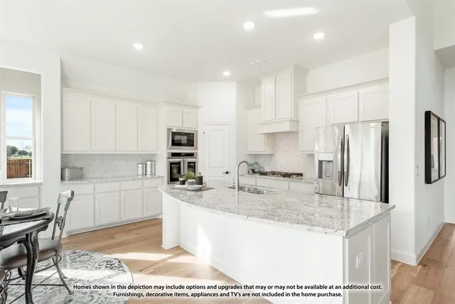 a kitchen with stainless steel appliances granite countertop a sink refrigerator and cabinets