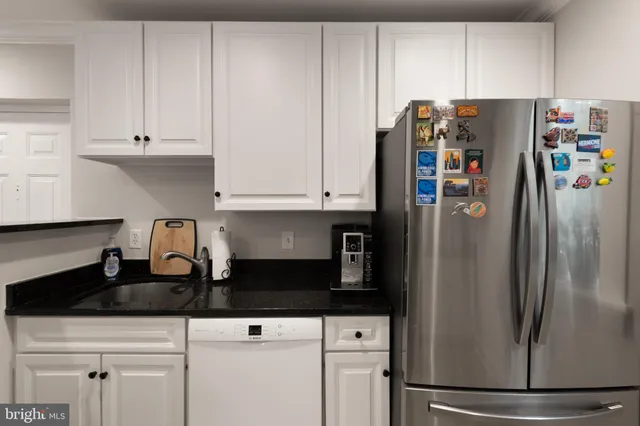 a kitchen with stainless steel appliances granite countertop a stove a sink and a white cabinets