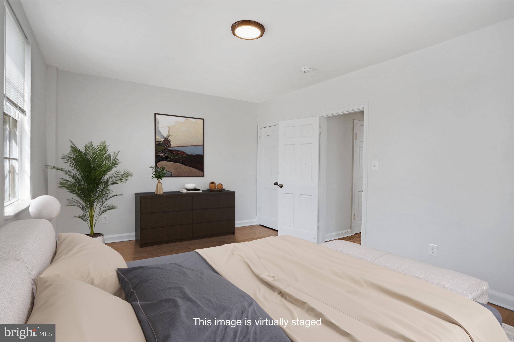 1446 Tuckerman Street Northwest, Unit 306 Washington, DC 20011 - Photo 14 of 26 a bedroom with a bed and a potted plant