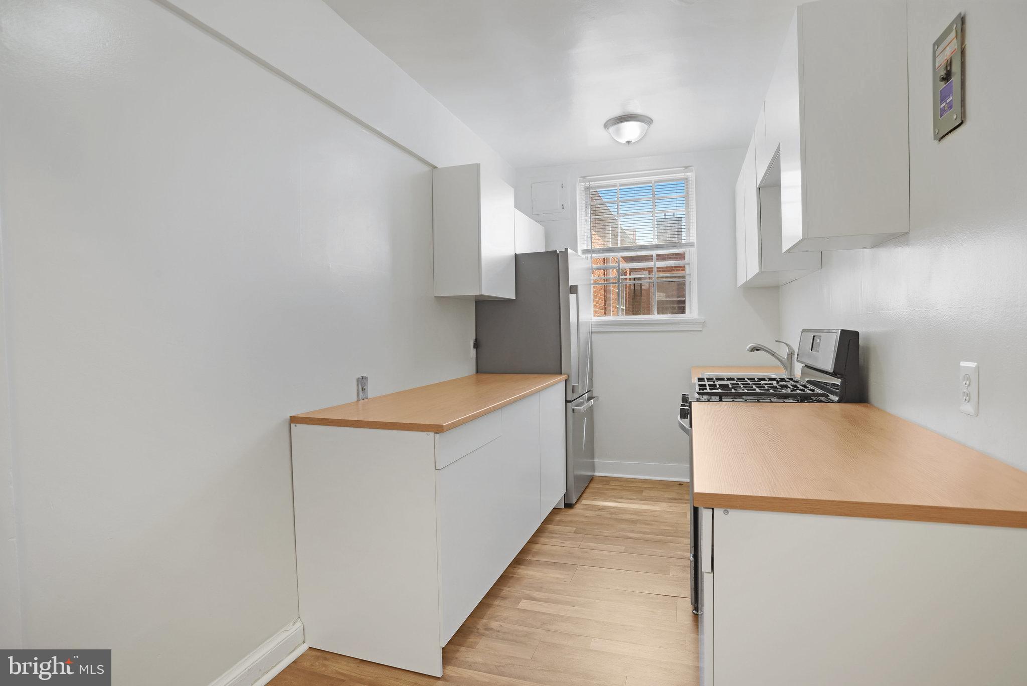 1446 Tuckerman Street Northwest, Unit 306 Washington, DC 20011 - Photo 5 of 26 a kitchen with stainless steel appliances a refrigerator and a stove