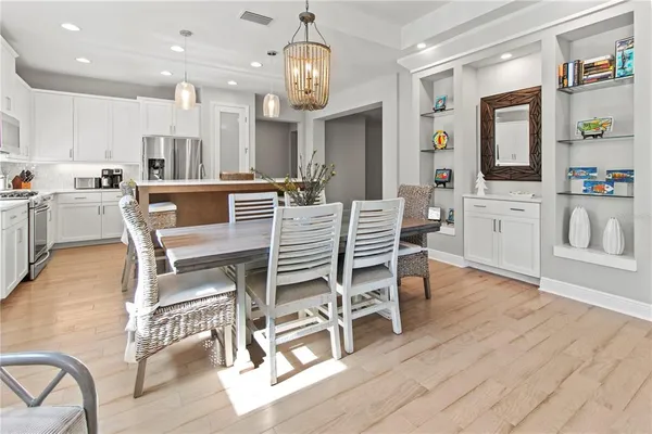 a very nice looking dining room with kitchen island stainless steel appliances a table and chairs