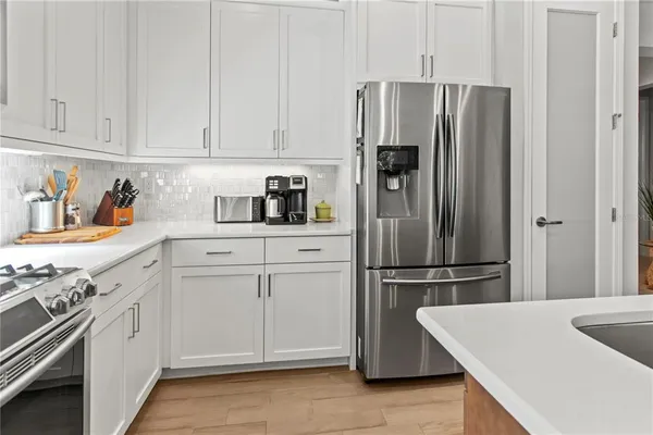 a kitchen with white cabinets stainless steel appliances and sink