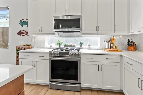 a kitchen with a refrigerator sink and cabinets