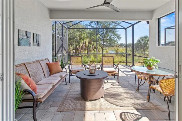a living room with patio furniture and a floor to ceiling window