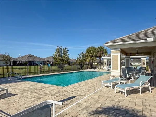 a view of a swimming pool with a patio and a garden