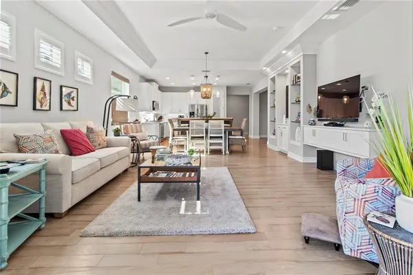 a living room with furniture a flat screen tv and kitchen view