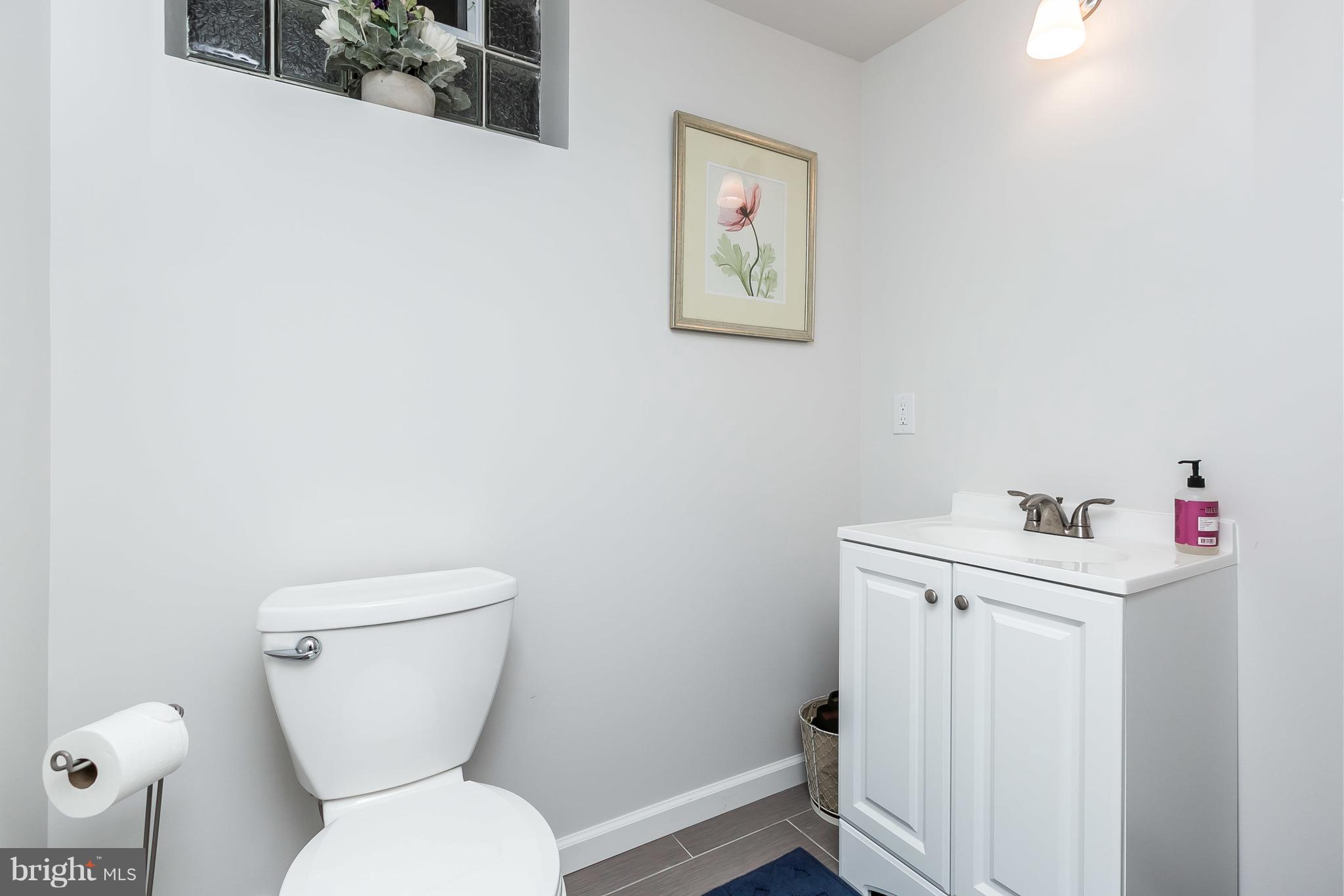 326 Overbrook Road Baltimore, MD 21212 - Photo 27 of 35 a bathroom with a toilet a sink and wooden floor