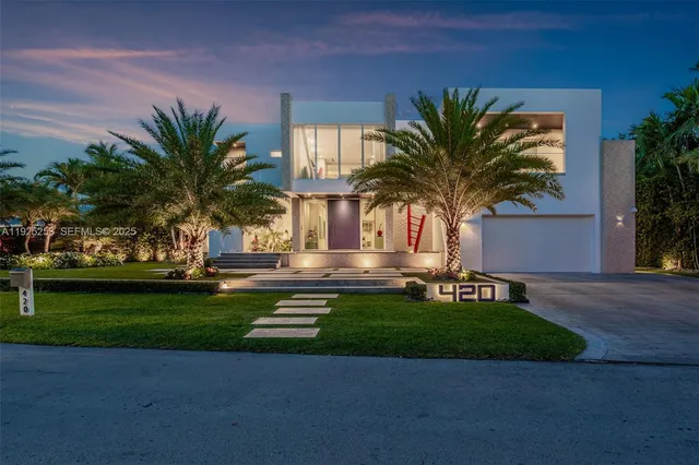 a view of a house with a yard and palm trees
