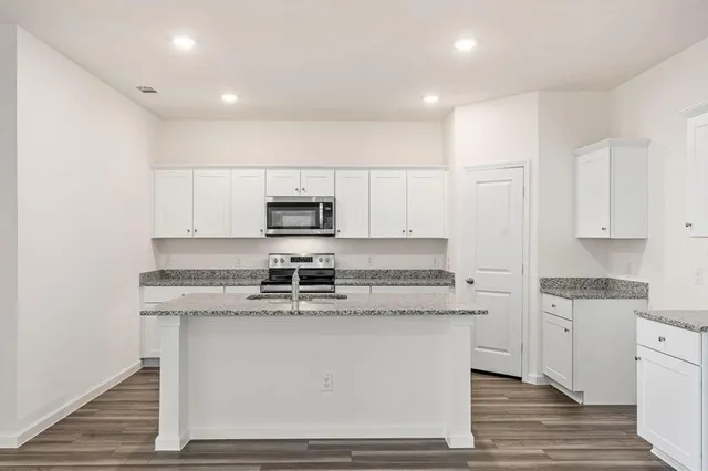 a view of kitchen view wooden floor stainless steel appliances and cabinets